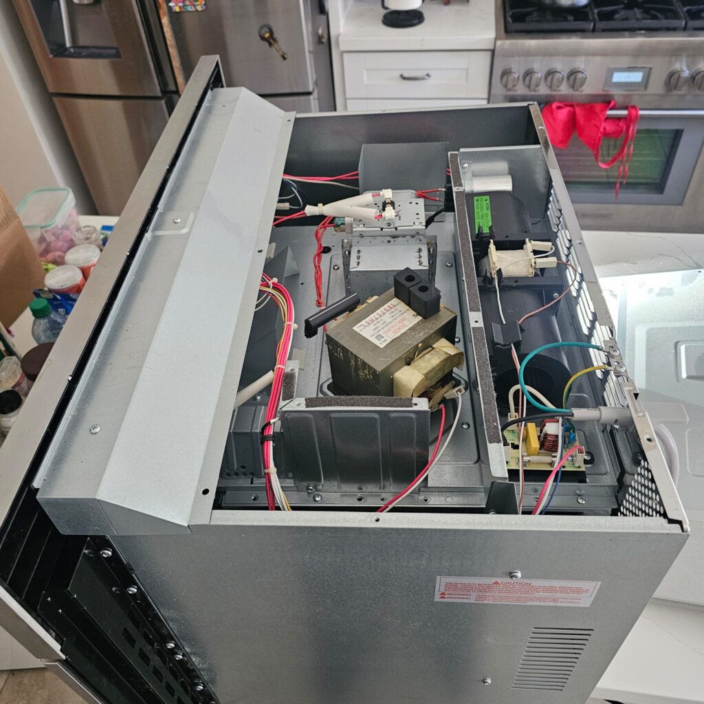 Bosch microwave not heating — internal high-voltage transformer and magnetron housing exposed during repair