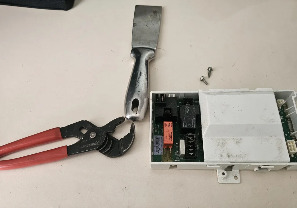 Disassembly phase showing the removal of the top console structural plate on a Kenmore Elite dryer.