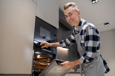 CFA technician calibrating and repairing a luxury gas range oven in Los Angeles