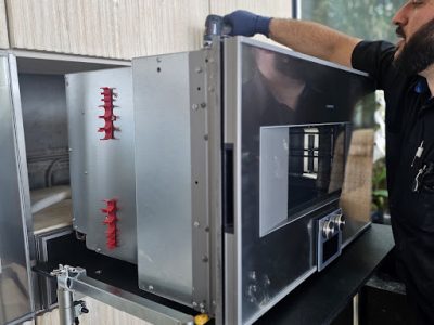 Technician repairing Gaggenau steam oven control panel and internal components in Los Angeles